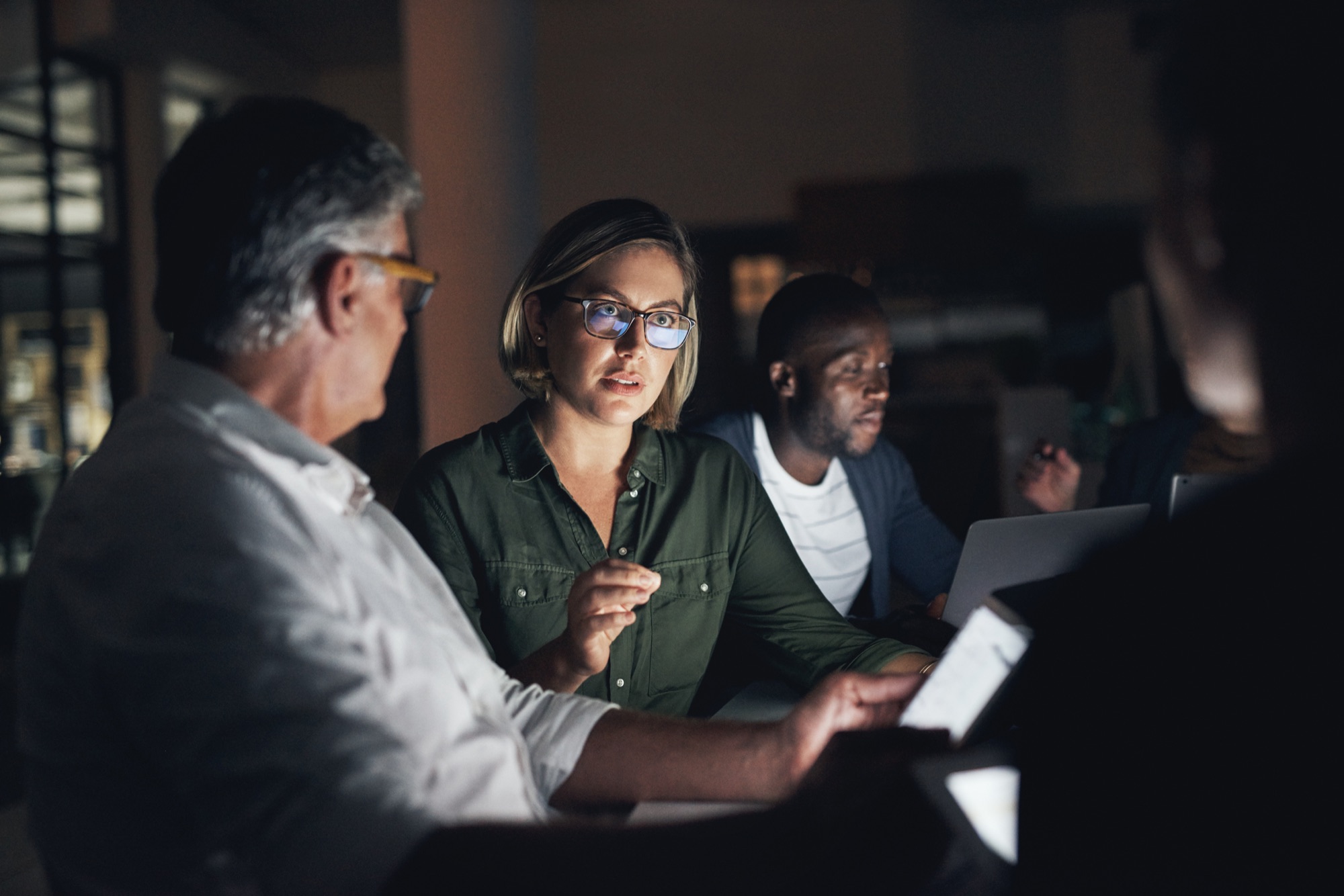 Ein Team arbeitet abends gemeinsam am Laptop